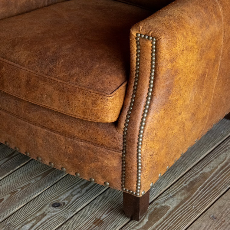 Rustic Distressed Brown Leather Ottoman with Button Tufting and Nailhead Trim, Angled Front View