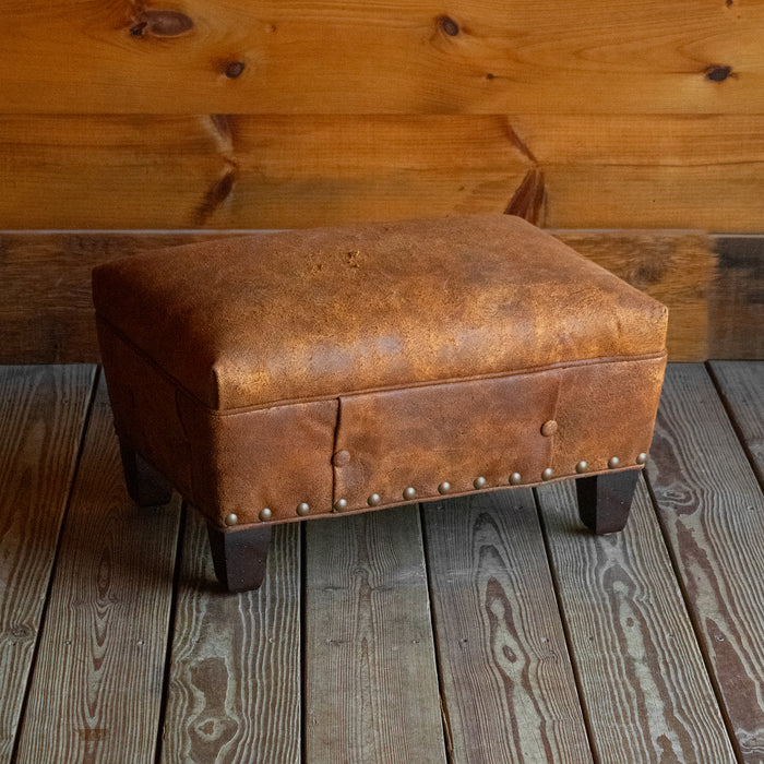 Rustic Distressed Brown Leather Ottoman with Button Tufting and Nailhead Trim, Angled Front View